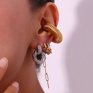 Detail of creative mixed gold and silver C-shaped wrap earrings on a female model