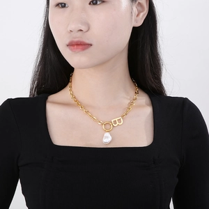 Gold letter B pendant necklace with irregular pearl on chunky chain worn by model