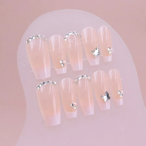 Faux ongles dégradés français avec papillon argenté et strass en forme de cercueil long