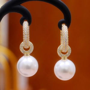 Close-up of elegant pearl drop earrings with sparkling crystal accents on gold base