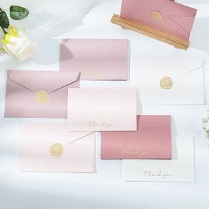 Close-up of pink and white folding cards with gold stamped Thank You and wax seals