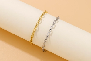 Detailed view of gold and silver hammered chunky chain bracelets on a display stand