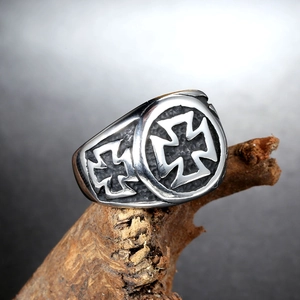 Close-up of vintage steel ring featuring double cross relief on a wood texture