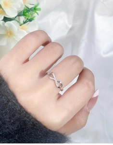 Detail of S925 silver infinity ring with sparkling crystals on a model's hand
