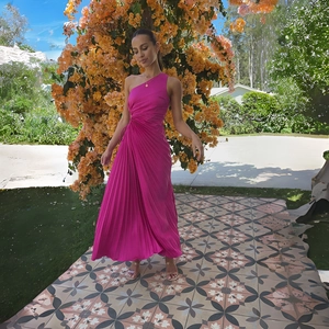 Detail of the elegant fuchsia one-shoulder pleated maxi dress with a flowing chiffon texture