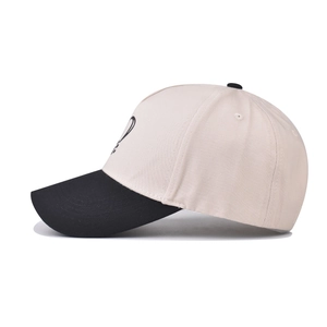 Detail view of cotton baseball cap with two-tone cream and black panels and side print