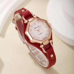 Gros plan d'une montre à quartz hexagonale en or rose avec bracelet en cuir rouge clouté