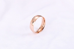 Detail of rose gold ring featuring geometric V-shaped engravings and mirror polished finish