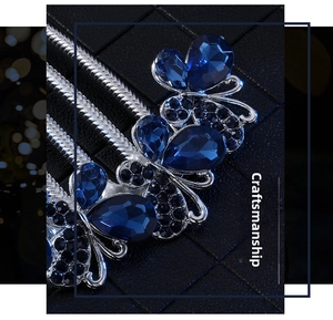 Detail of silver hair comb with blue pear-shaped rhinestones and crystal flower pattern