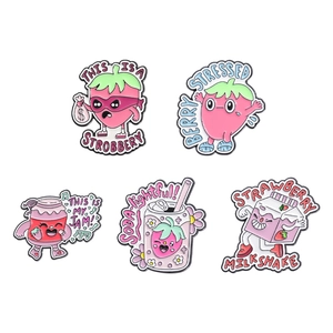 Set of five cute pink strawberry cartoon enamel pins with funny fruit puns in flat lay view
