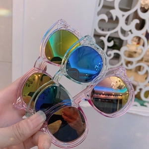 Close-up of children's pink plastic sunglasses with colorful reflective rainbow lenses