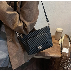 Détail du sac bandoulière plissé noir avec boucle métallique et texture en similicuir