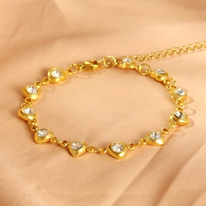 Elegant gold stainless steel bracelet with heart zircon charm on champagne silk backdrop