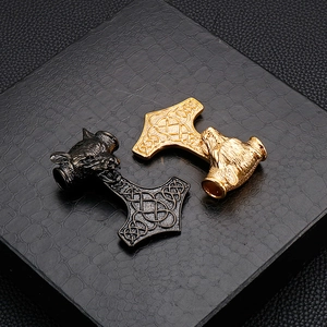 Détail de pendentifs marteau de Thor tête de loup en argent et or sur cuir noir