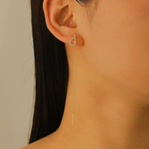 Macro view of gold drop earrings with micro-pave zircons and long fine tassels