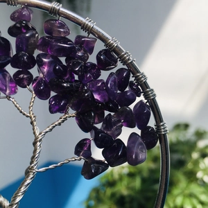 Macro detail of handmade silver wire tree of life pendant with purple amethyst crystals