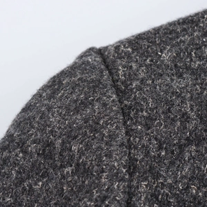Macro shot of dark grey wool blend fabric showing shoulder seam details and texture