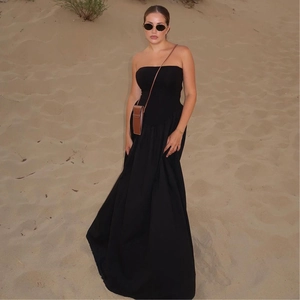 Elegantes schwarzes trägerloses Maxikleid, das in einer Wüstenlandschaft sanft weht