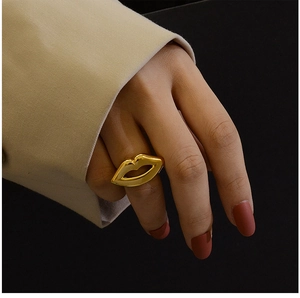 Close-up of a high-shine 18K gold-plated lip-shaped ring on a model's finger