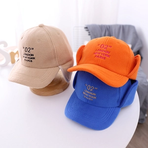 Close-up of children's fleece ear protection baseball caps in khaki, orange, and blue colors