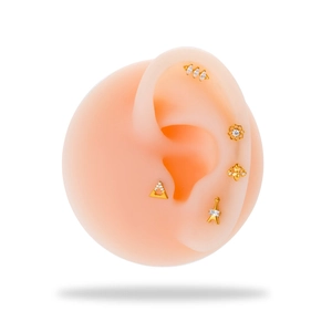Macro detail of G23 titanium gold stud earrings with cubic zirconia on silicone ear model