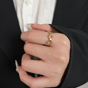Detail of gold chain link ring worn on finger with a professional business attire