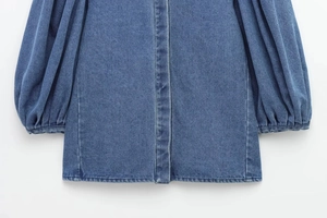 Detailed macro view of the washed denim fabric and elastic cuffs on this blue denim shirt