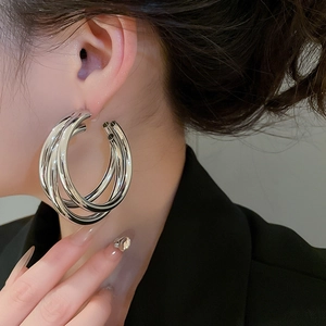 Detailed view of silver multi-layered hoop earrings worn to show style and size