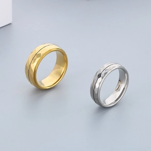 Detailed view of geometric diamond-cut stainless steel rings in gold and silver finish