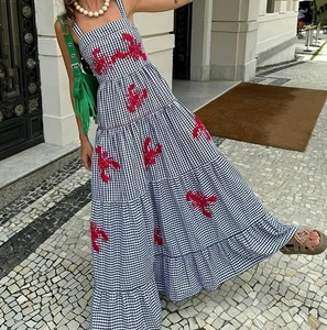 Detail of red lobster embroidery on black and white checkered tiered pleat maxi dress