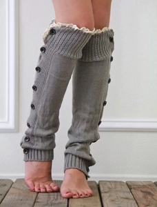 Detail of grey knitted leg warmers with vintage black buttons and white lace trim
