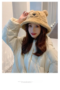 Close-up of khaki plush bucket hat with bear ears and embroidery on a model