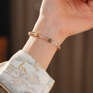 Gros plan d'un bracelet en perles de quartz multicolores porté au poignet, style vintage chic