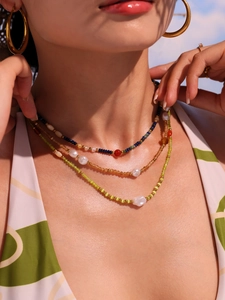 Close-up of bohemian layered beaded necklace with lapis lazuli and red agate on model