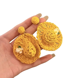 Handmade raffia straw hat earrings in bright yellow with white flower details for vacation