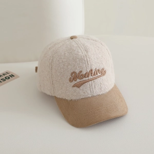 Détail du tissu en laine d'agneau et broderie Nothing sur la casquette enfant