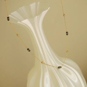 Collana di perle blu cielo stellato con perline dorate e catena in acciaio al titanio