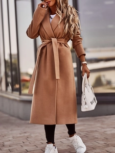 Close-up of camel wool trench coat showing the tied waist belt and fabric texture