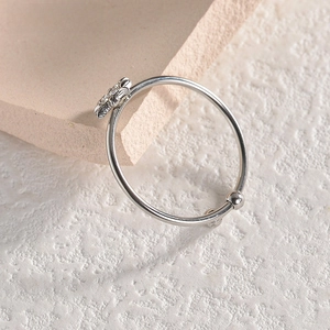 Close-up of a silver floral open ring with flower and bead detail on a textured base