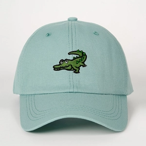 Detail of mint green cotton baseball cap featuring green cartoon crocodile embroidery