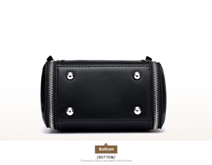 Detail view of the black leather bucket bag base featuring four silver metal feet studs