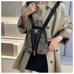 Close-up of leopard print stitching and gold zipper detail on a black PU leather backpack
