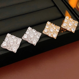 Détail de boucles d'oreilles carrées dorées et argentées avec pavé de zircons cubiques