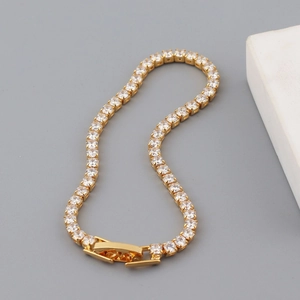 Close-up of gold tennis chain bracelet featuring square cubic zirconia and hollow clasp