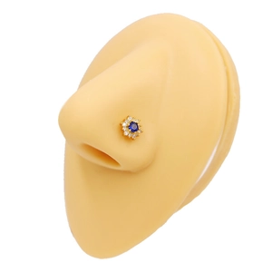 Vue détaillée d'un piercing nez fleur avec pierre bleue centrale sur un nez mannequin