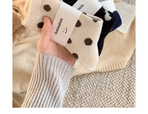 Gros plan de chaussettes épaisses en laine à motif à pois classiques multicolores