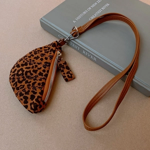 Macro view of leopard print triangular mini bag with brown faux leather strap