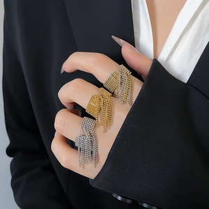 Detail of beaded fringe tassel rings in gold and silver finish on a model hand