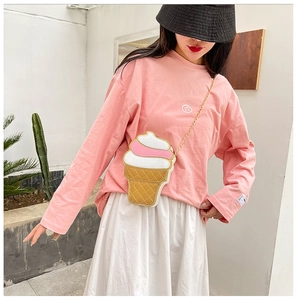 Detail of pink ice cream cone crossbody bag worn by a model in a minimal setting