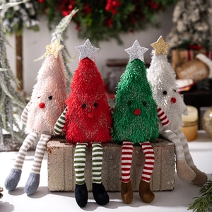 Close-up of cute plush Christmas tree dolls with long striped legs in a festive setting